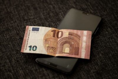 Billet de 10 euros posé sur un smartphone affichant une application bancaire